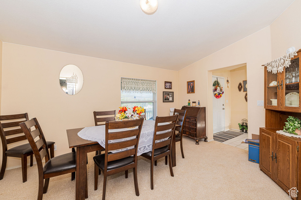 Dining room with light carpet and vaulted ceiling