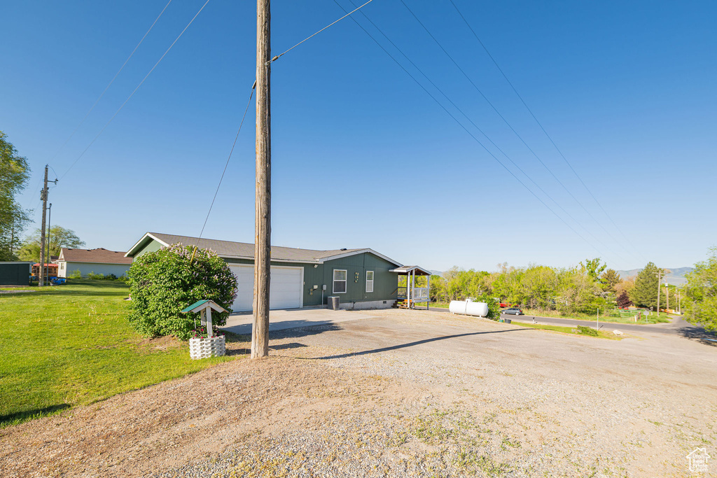 Ranch-style house with driveway, a garage, and a front yard