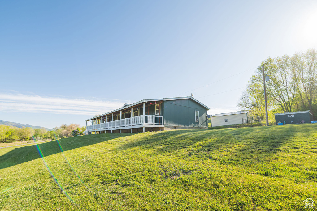 Rear view of house featuring a sunroom and a yard