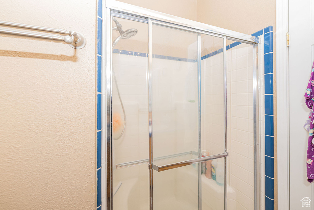 Bathroom with a shower stall and a textured wall