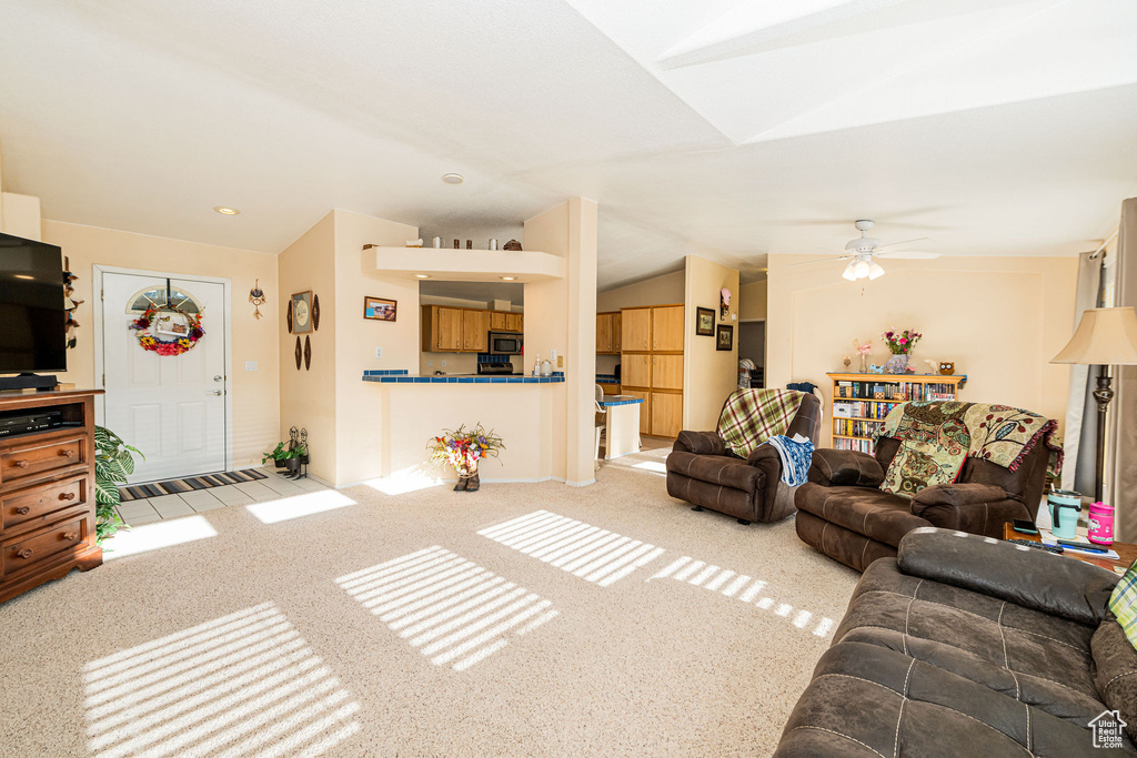 Carpeted living area with lofted ceiling and a ceiling fan