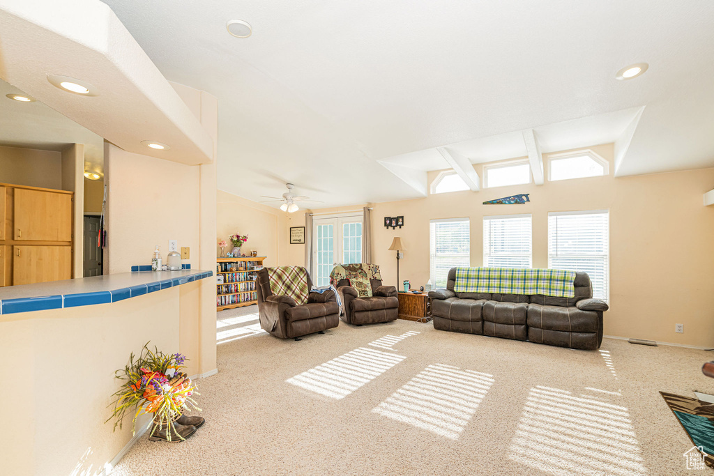 Carpeted living area with vaulted ceiling, ceiling fan, recessed lighting, and baseboards