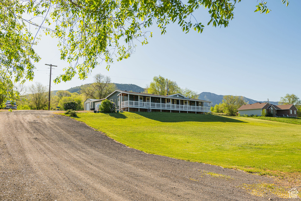 View of front of home featuring a front lawn, a mountain view, and driveway