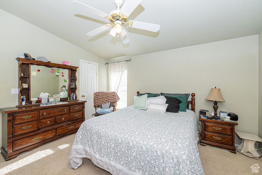 Bedroom with light carpet, vaulted ceiling, and ceiling fan