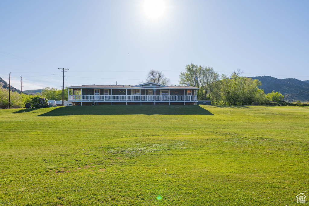 Back of property featuring a yard and a mountain view