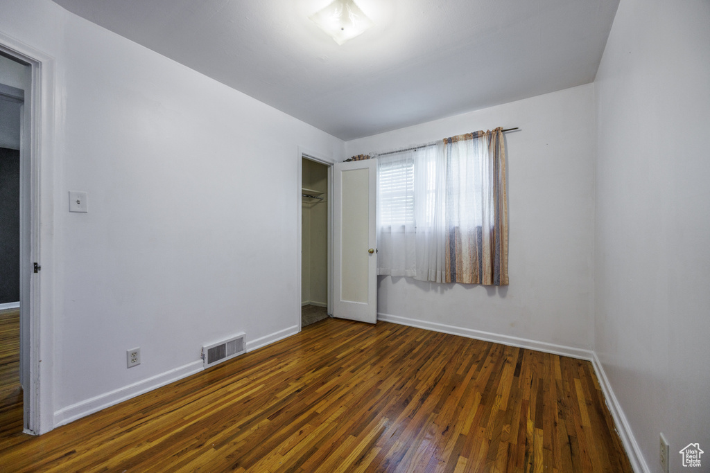 Unfurnished bedroom with baseboards, wood finished floors, and a closet