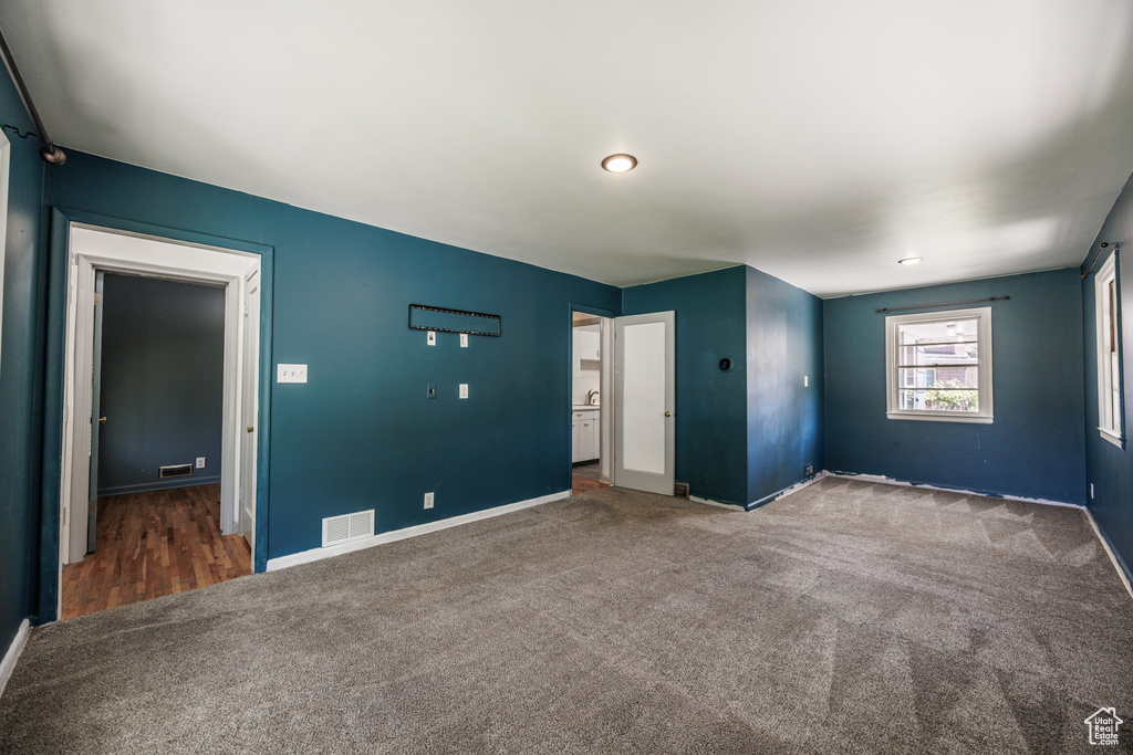 Carpeted spare room featuring baseboards