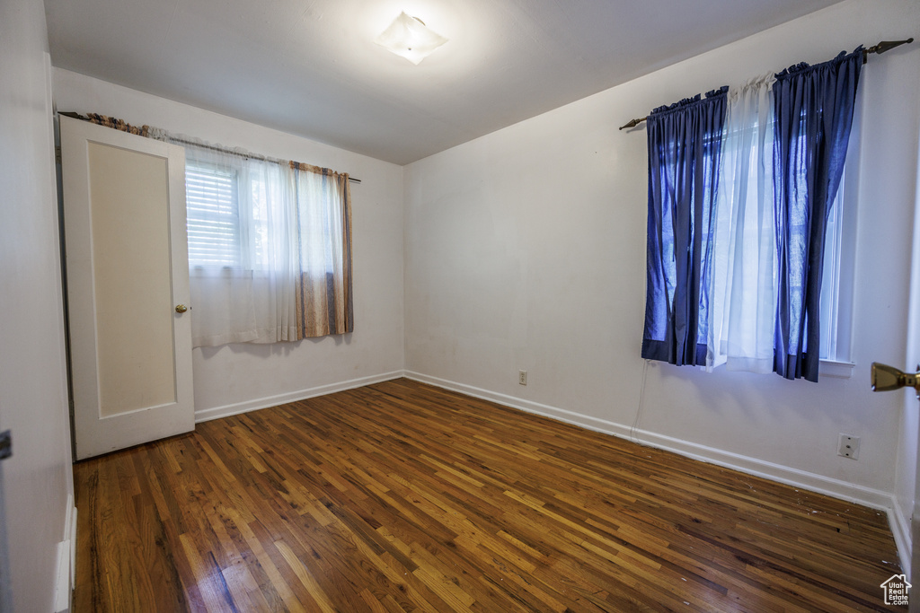 Empty room with hardwood / wood-style flooring and baseboards