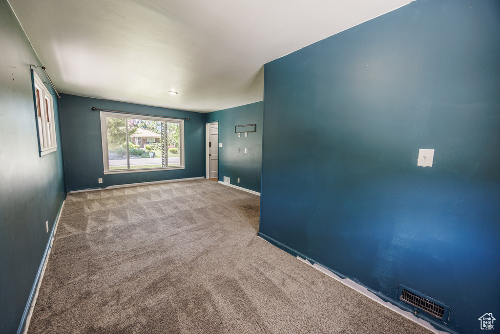 Carpeted spare room with baseboards
