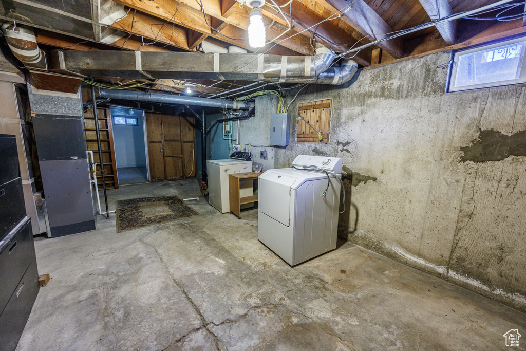 Below grade area with washer and clothes dryer and electric panel