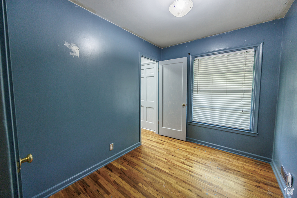 Unfurnished bedroom with wood finished floors and baseboards