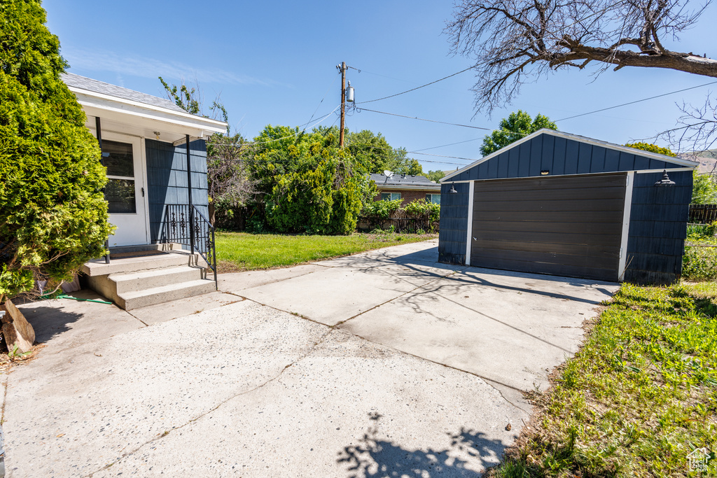 View of patio / terrace featuring a garage and an outbuilding