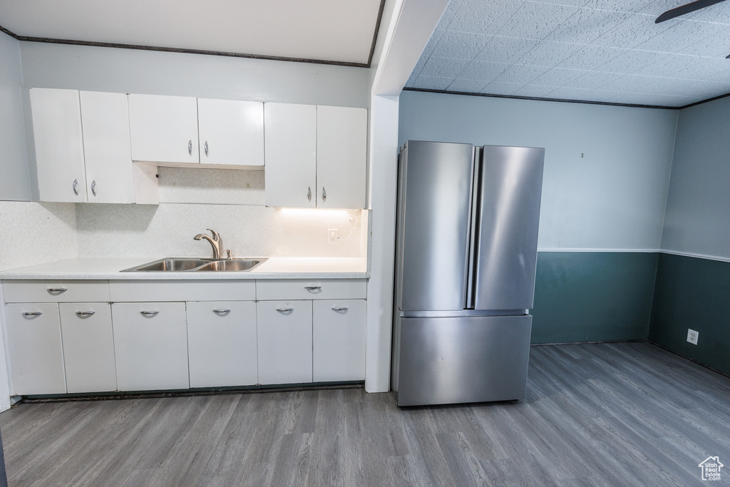 Kitchen with freestanding refrigerator, a sink, light wood-type flooring, and light countertops