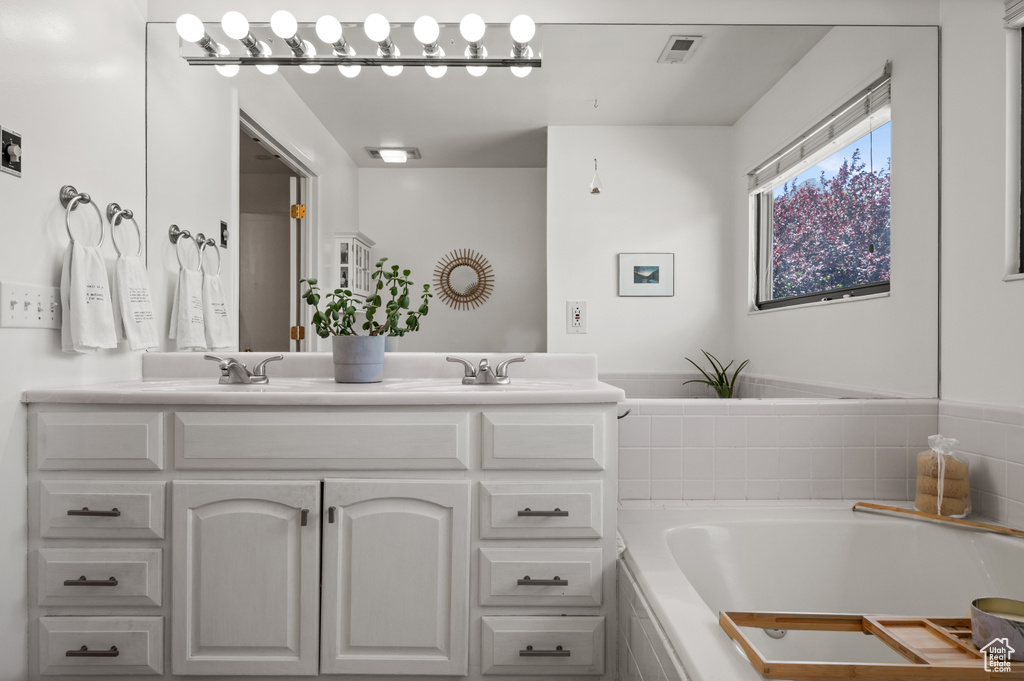 Full bathroom with double vanity and a bath