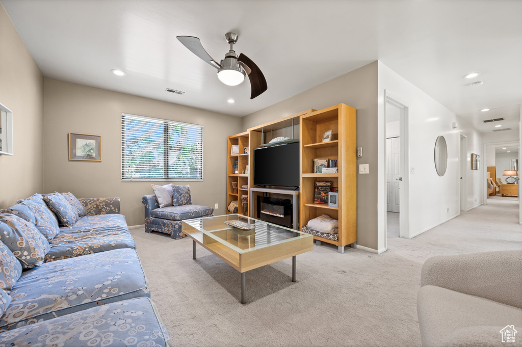 Living room with carpet flooring, ceiling fan, baseboards, and recessed lighting