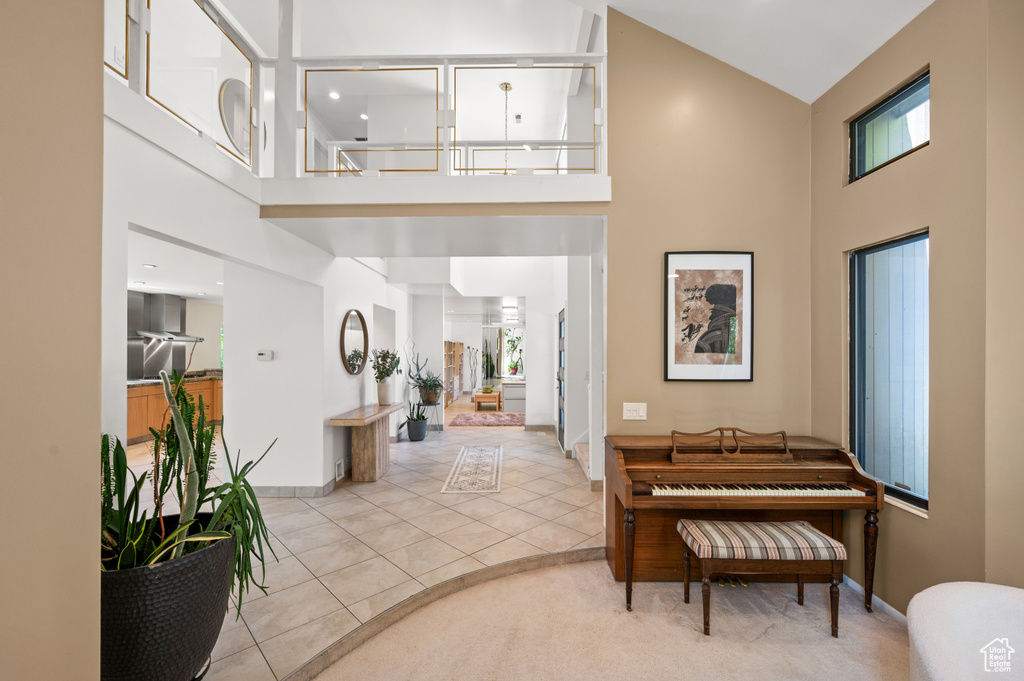 Tiled foyer featuring a towering ceiling and baseboards
