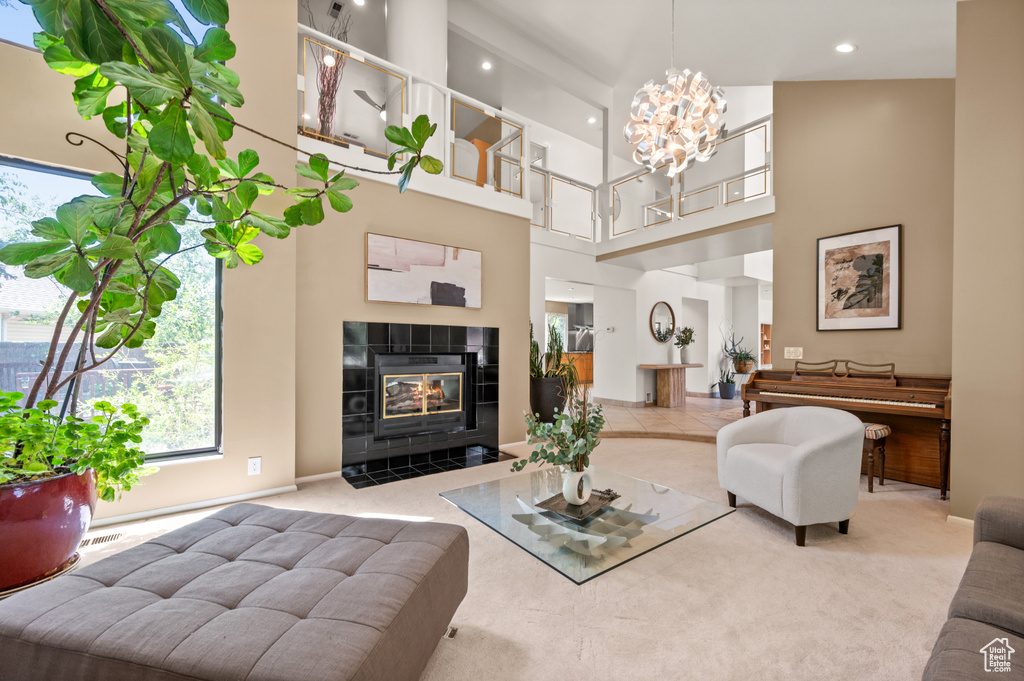 Living room featuring carpet, healthy amount of natural light, recessed lighting, a high ceiling, and a chandelier