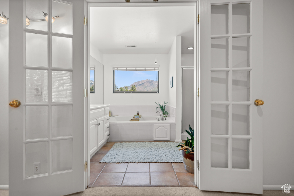 Bathroom featuring a garden tub, vanity, and tile patterned floors