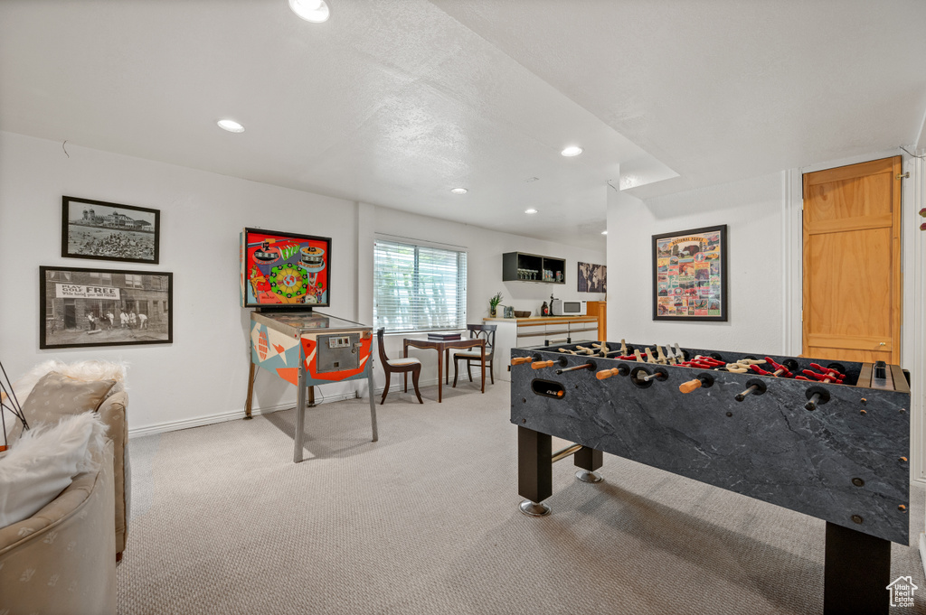 Recreation room with light carpet, recessed lighting, and baseboards