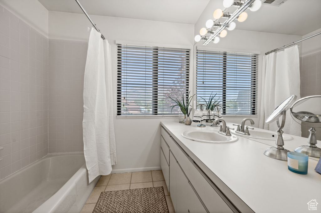 Full bath featuring tile patterned flooring, plenty of natural light, vanity, and shower / tub combo