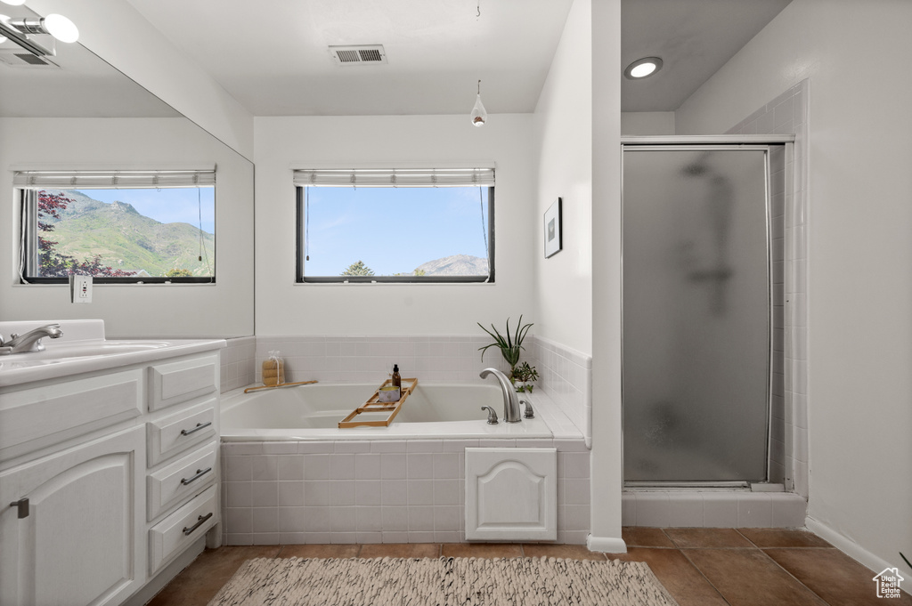 Full bath featuring vanity, a stall shower, a garden tub, and tile patterned floors