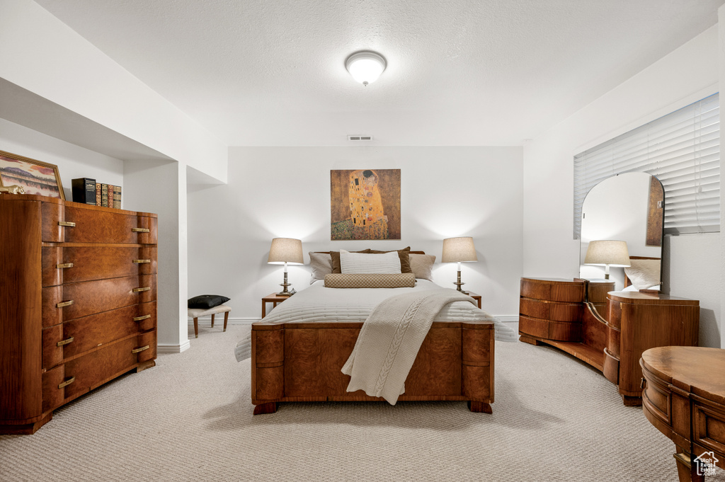 Bedroom featuring light carpet and baseboards