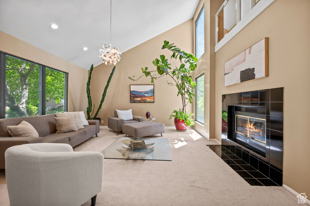 Living area with carpet, a chandelier, a tiled fireplace, baseboards, and recessed lighting