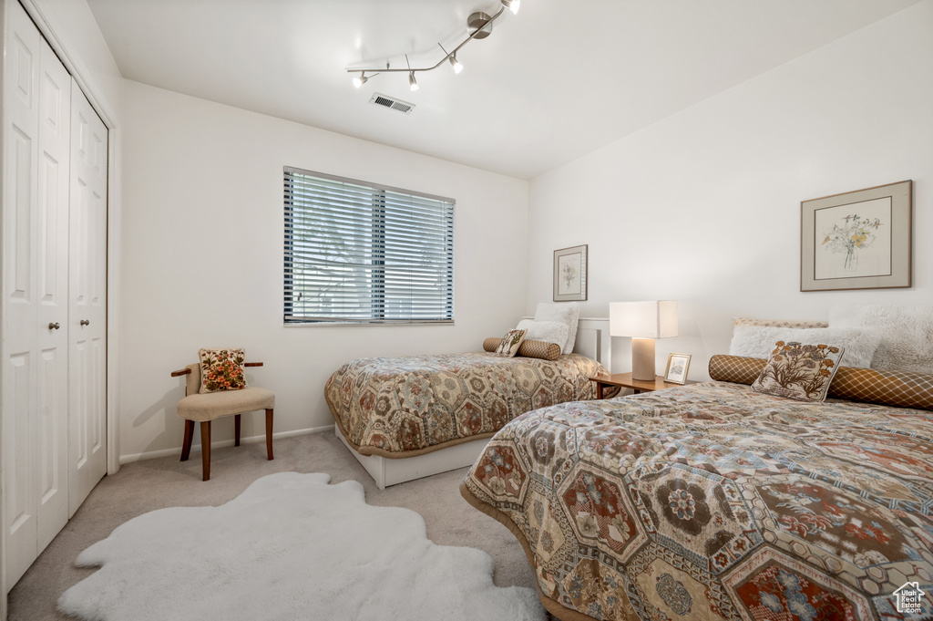 Carpeted bedroom with a closet and baseboards