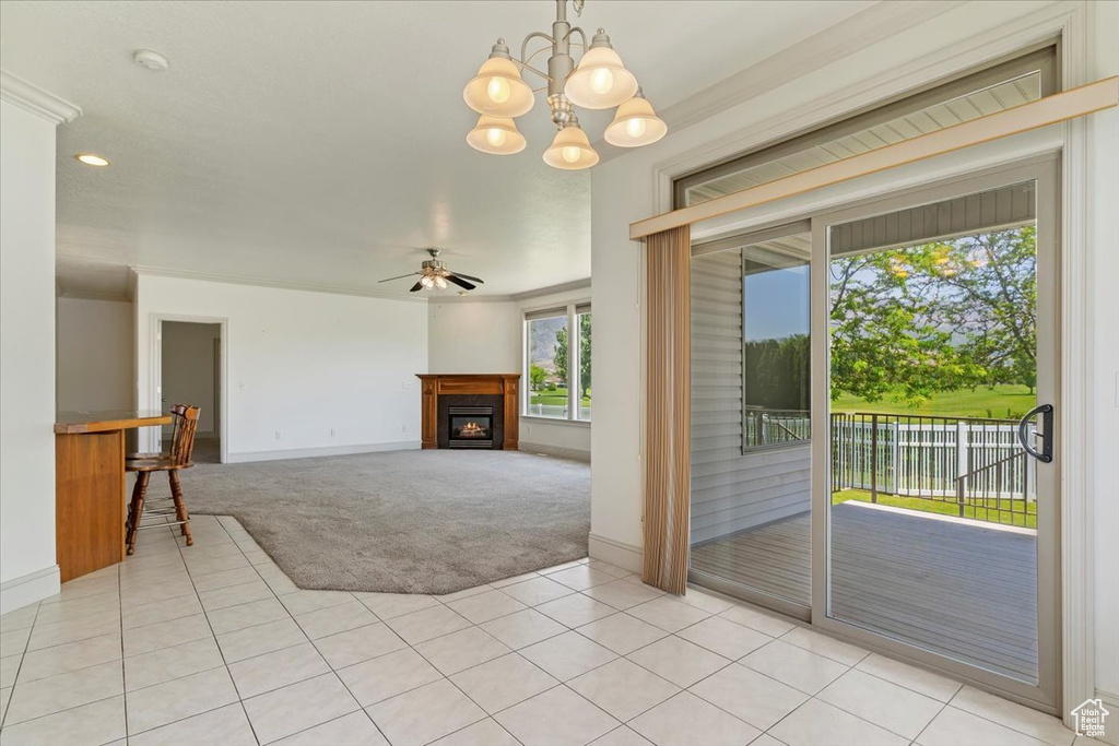 Unfurnished living room with light colored carpet, baseboards, ceiling fan, a warm lit fireplace, and light tile patterned floors