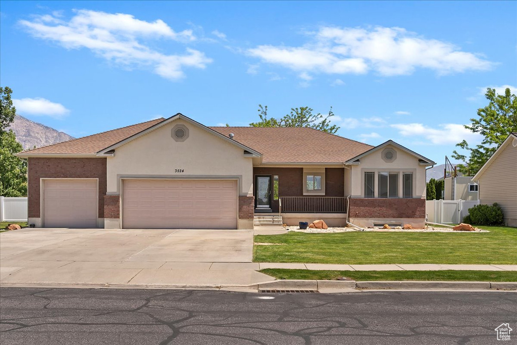 Single story home featuring a garage, concrete driveway, stucco siding, and covered porch