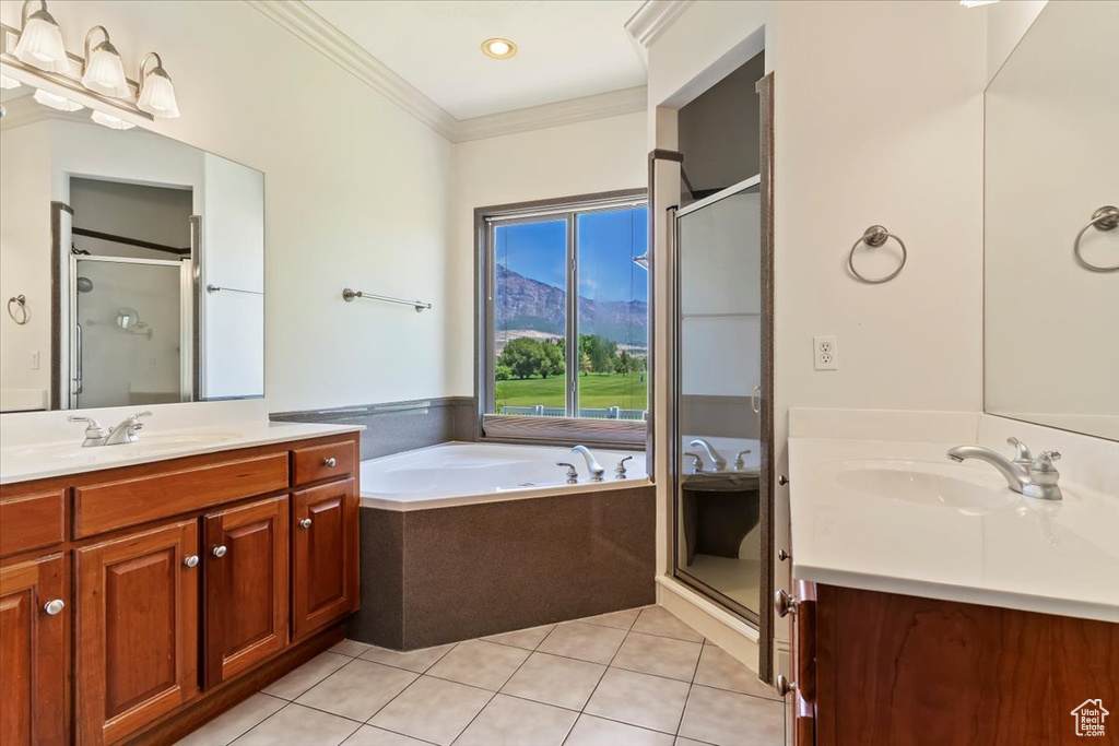 Full bath with tile patterned flooring, vanity, ornamental molding, a stall shower, and a bath