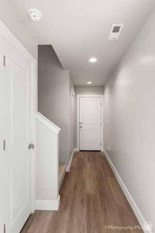 Hallway featuring baseboards, wood finished floors, and recessed lighting