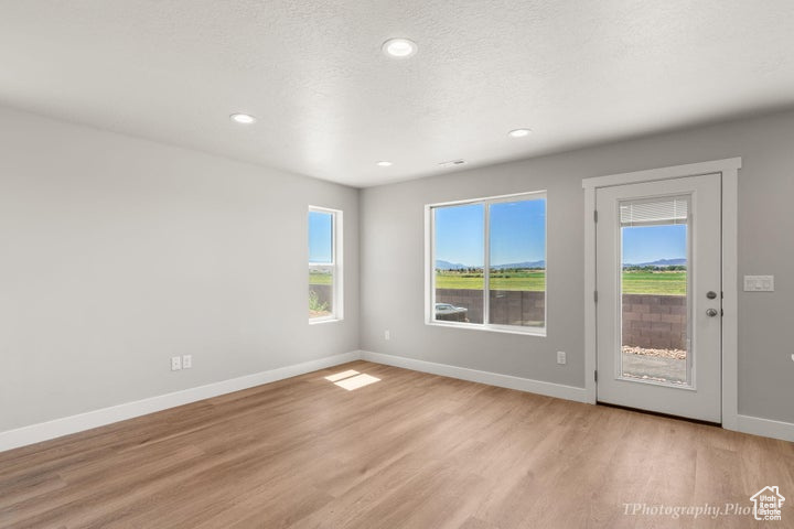 Unfurnished room featuring light wood finished floors, baseboards, and recessed lighting