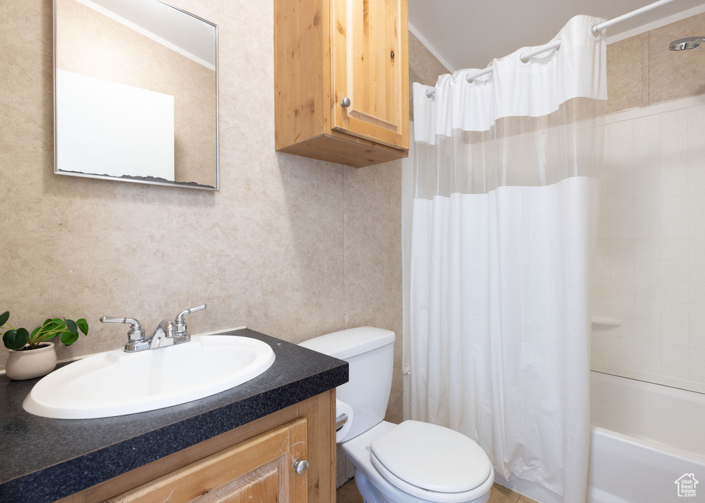 Bathroom with vanity, toilet, and shower / tub combo with curtain
