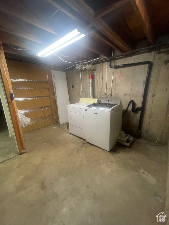 Unfinished basement featuring washing machine and clothes dryer