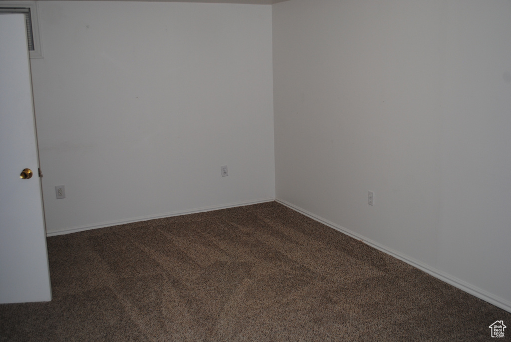 Carpeted spare room featuring baseboards