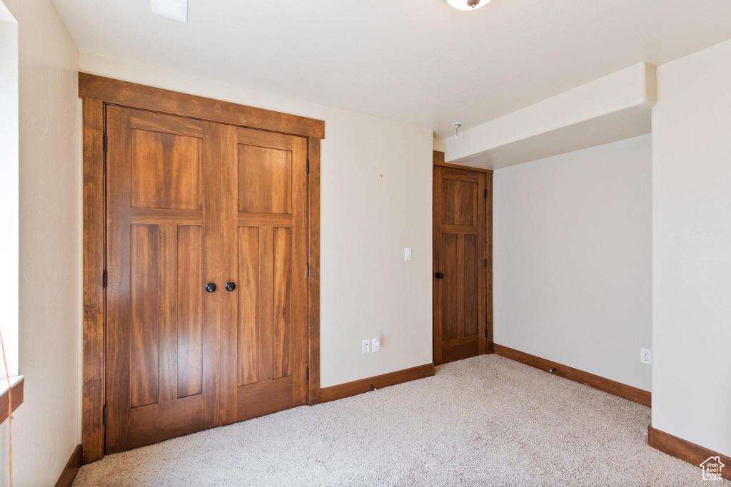 Unfurnished bedroom featuring baseboards, carpet, and a closet