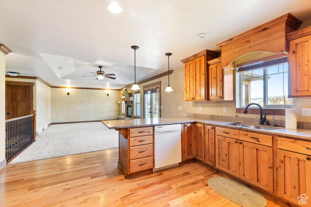 Kitchen with dishwasher, a sink, open floor plan, a peninsula, and light wood-style floors