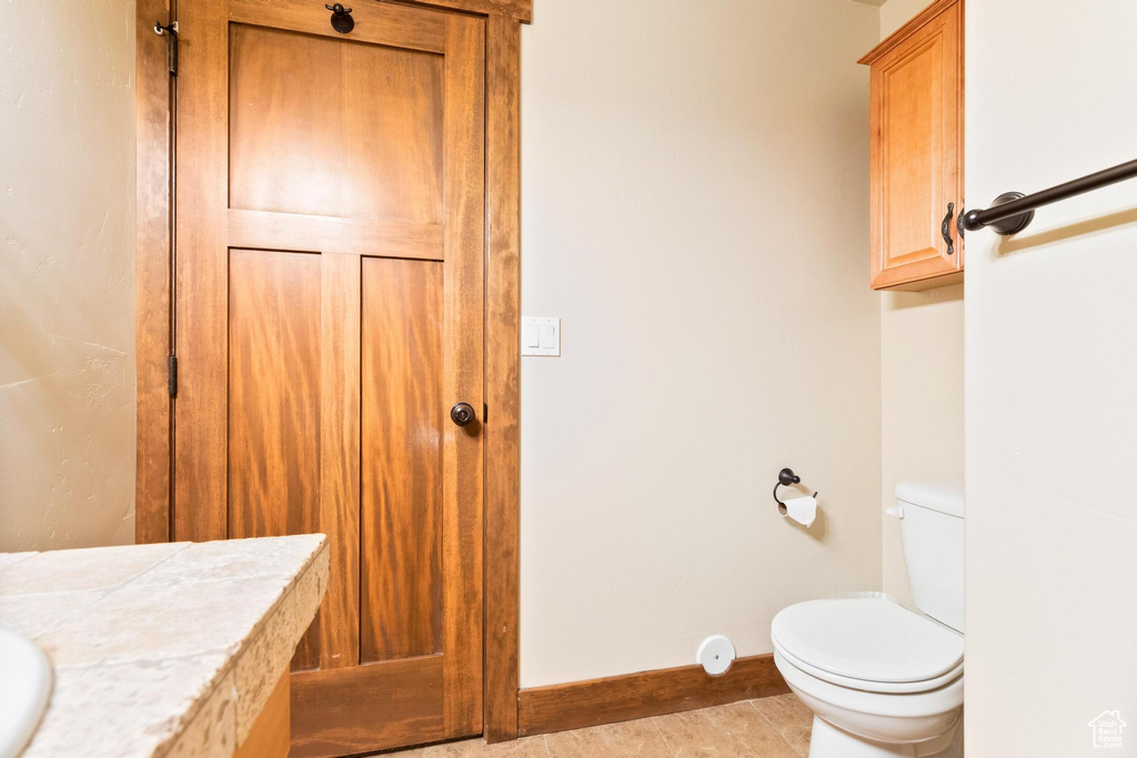 Bathroom with toilet, baseboards, and vanity