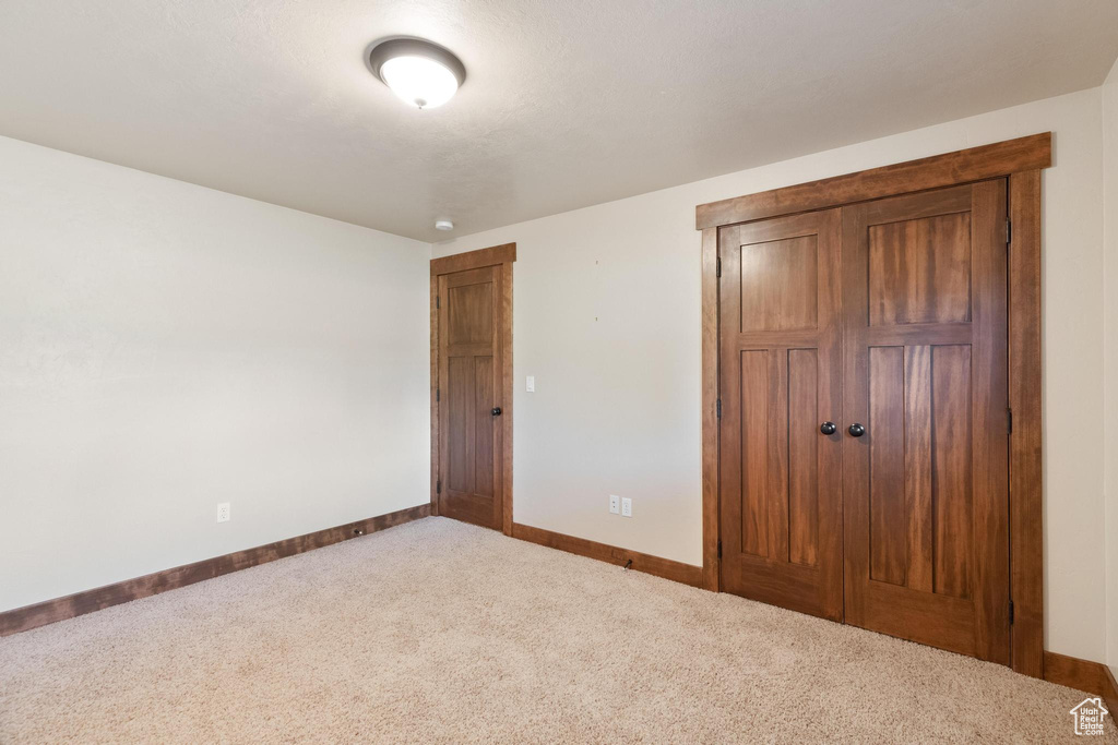 Unfurnished bedroom with carpet flooring, baseboards, and a closet