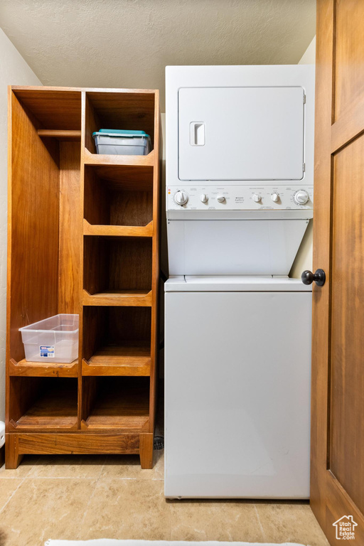 Washroom featuring stacked washing machine and dryer