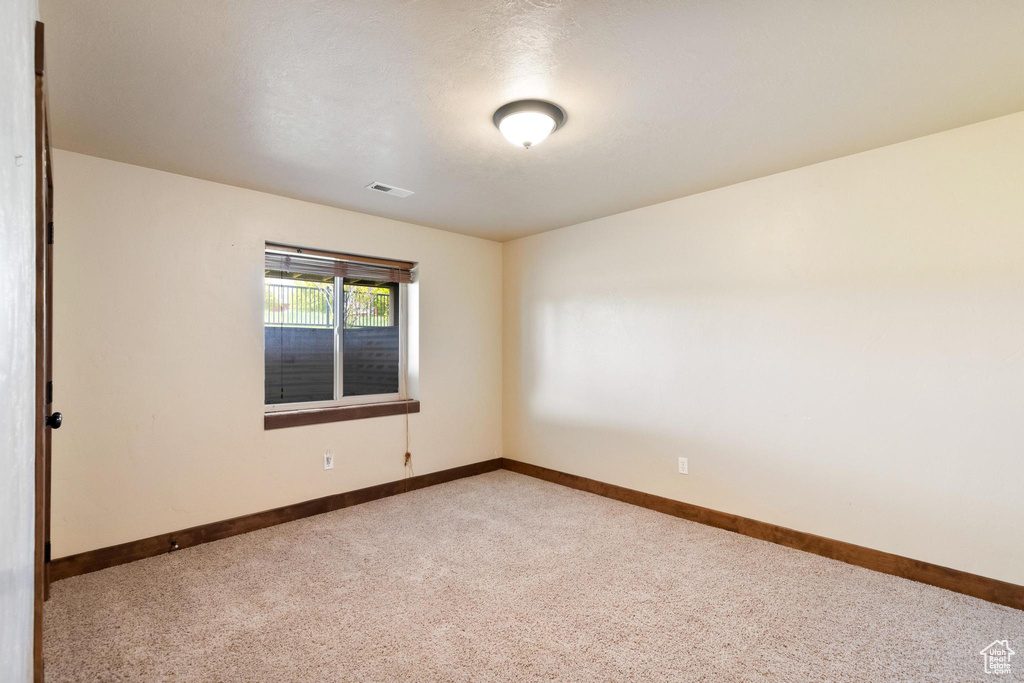 Carpeted empty room with baseboards