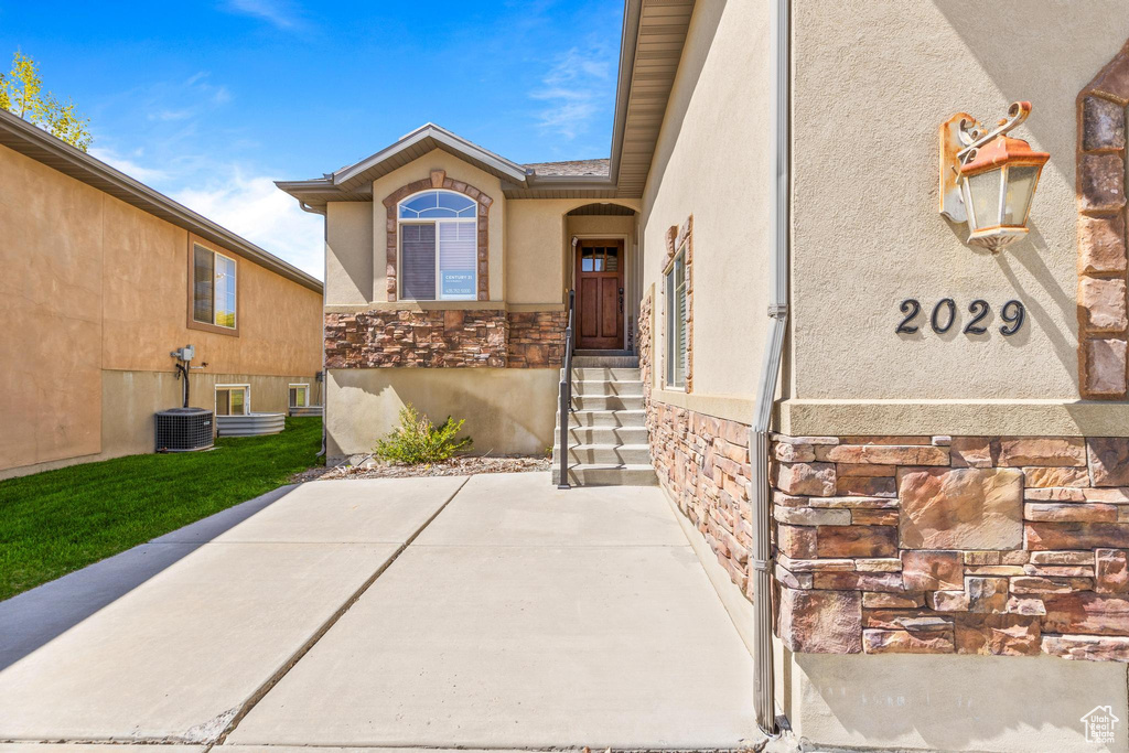 Entrance to property with stone siding and stucco siding