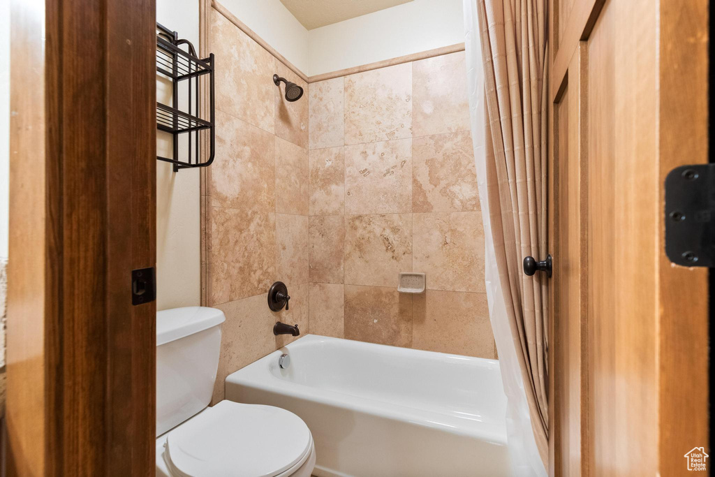Full bathroom with shower / bath combination with curtain and toilet