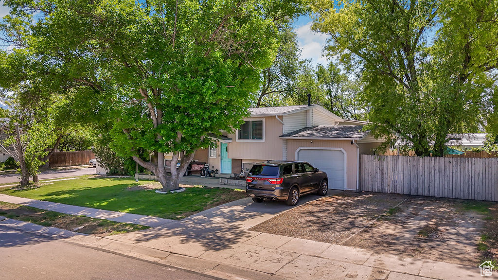 View of front facade featuring an attached garage, driveway, and stucco siding