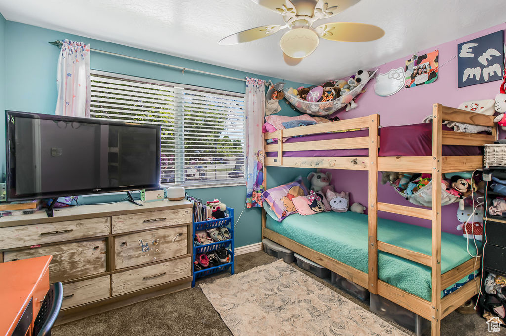 Carpeted bedroom featuring a ceiling fan and baseboards