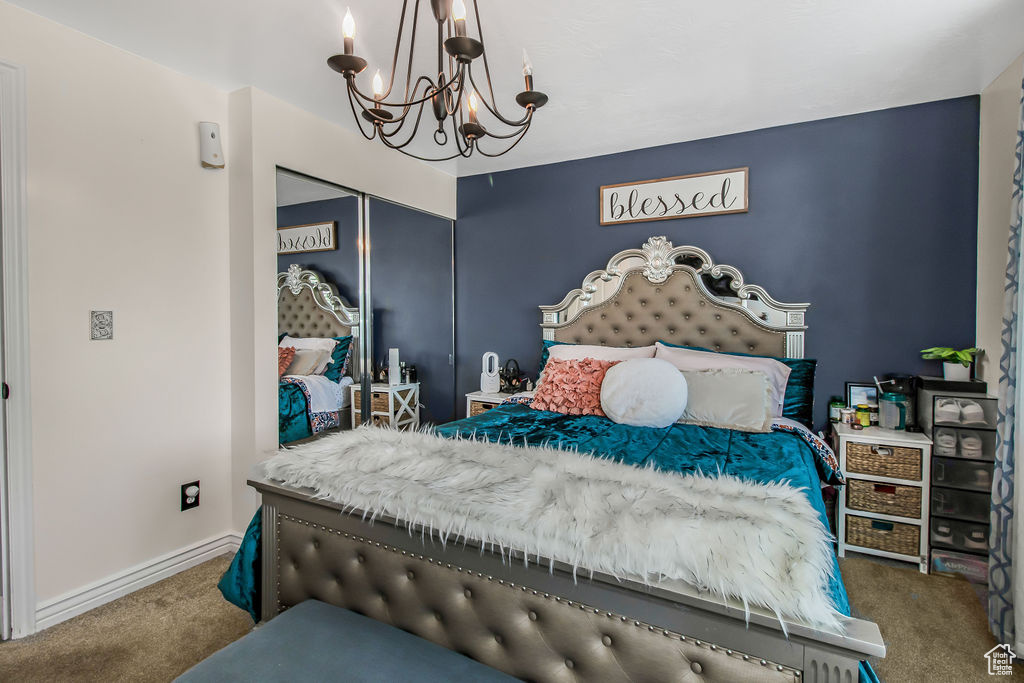 Bedroom with carpet flooring, a chandelier, a closet, and baseboards