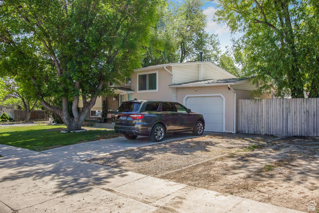 Split level home with concrete driveway and a garage
