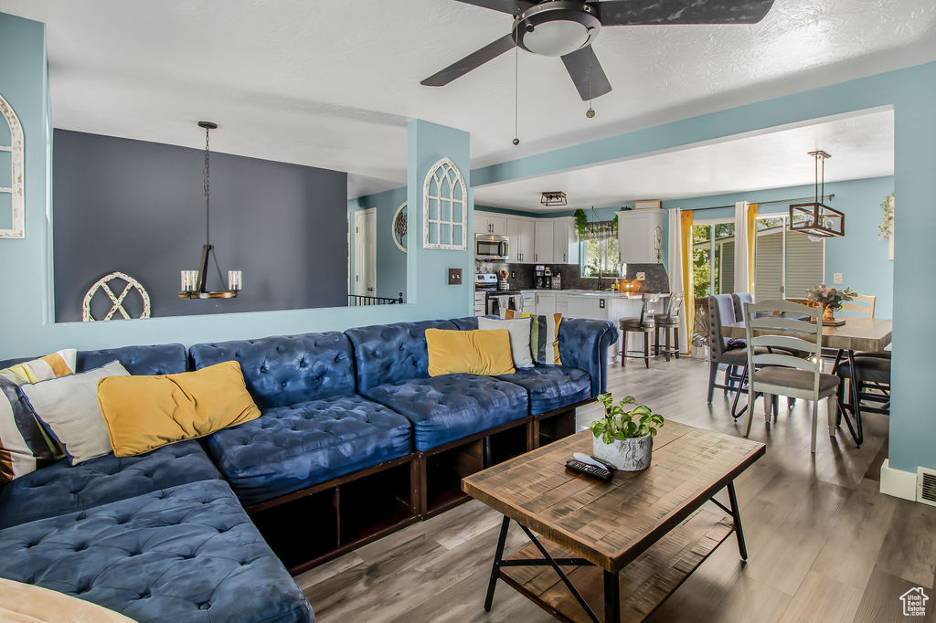 Living room featuring a ceiling fan and light wood-style flooring