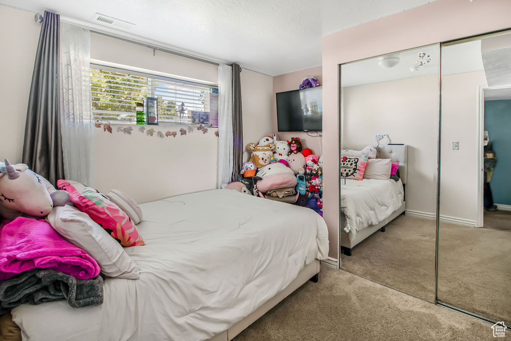 Carpeted bedroom featuring a closet and baseboards